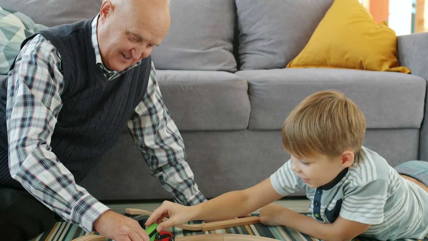 Grandfather playing with his young grandson in the living room