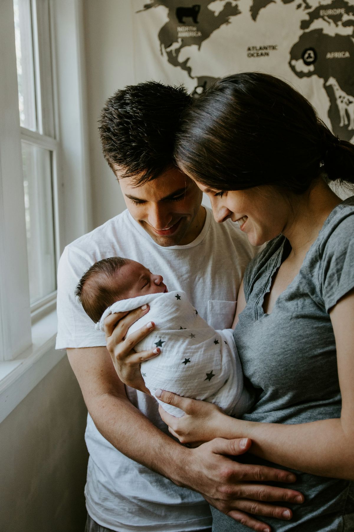 Young parents smiling down at their newborn baby